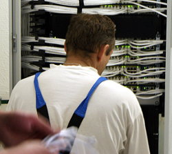 Монтажник выполняет работы по подключению оборудования в серверном шкафу