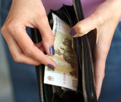 Девушка пересчитывает денежные банкноты в кошельке