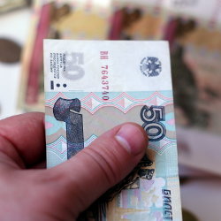 Фотография денежной купюры в мужской руке