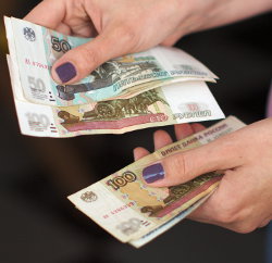 Женщина пересчитывает денежные банкноты