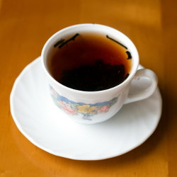 Фотография чашки со свежезаваренным чаем пуэр