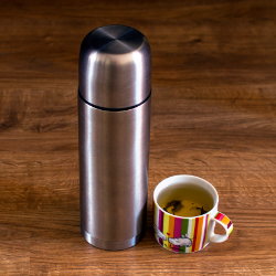 Фотография чашки чая рядом с термосом