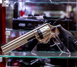 Фотография пистолета на витрине оружейного магазина